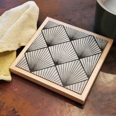 a wooden cutting board sitting on top of a table next to a potted plant