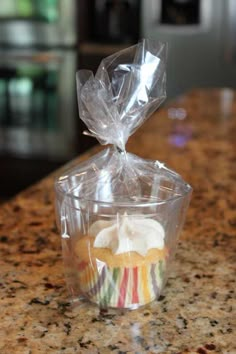 cupcakes wrapped in plastic sitting on top of a counter