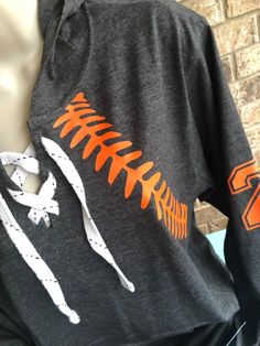 an orange and white baseball t - shirt on a mannequin's torso