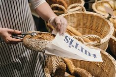 a person in an apron is cutting bread