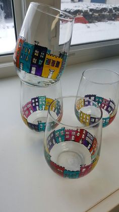 three wine glasses sitting on top of a window sill