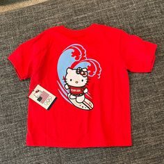 Team Usa Hello Kitty Surfing Olympics 3t T-Shirt Nwt Be Happy Shirt, Playful Red T-shirt With Cartoon Print, Playful Red Cartoon Print T-shirt, Playful Red T-shirt With Character Print, Casual Red T-shirt With Hello Kitty Print, Red Hello Kitty Cotton T-shirt, Red Cotton Hello Kitty T-shirt, Red Cotton T-shirt With Hello Kitty Print, Red Short Sleeve T-shirt With Cartoon Print