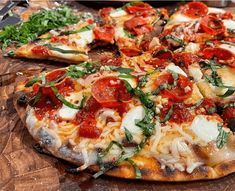 a pizza sitting on top of a cutting board covered in cheese and veggies