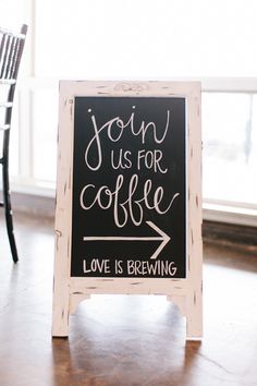 a sign that says join us for coffee love is brewing on it next to a chair