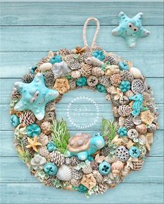 a wreath made out of seashells and starfish on a blue wooden background