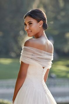 a woman in a white wedding dress posing for the camera with her hand on her hip