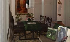 a dining room table with chairs and pictures on the wall next to an easel