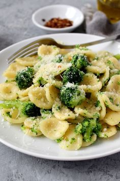 a white plate topped with pasta and broccoli