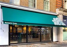 a storefront with green awnings on the side of it's building