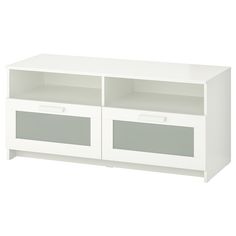 a white entertainment center with two doors and drawers on one side, in front of a white background