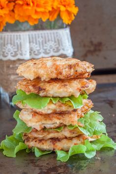 a stack of food sitting on top of a table next to an orange and yellow flower