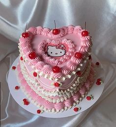 a hello kitty heart shaped cake with cherries