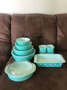 a brown couch with teal colored dishes on it