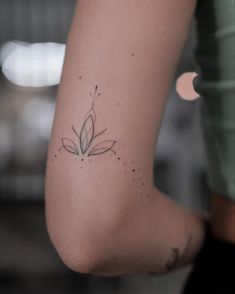 a woman's foot with a small flower tattoo on the left side of her leg