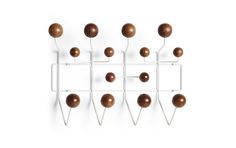 a white wall mounted rack with wooden balls on it's sides and two metal pegs attached to the hooks