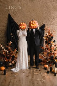 two people dressed up as jack - o'- lanterns and holding pumpkins in front of them