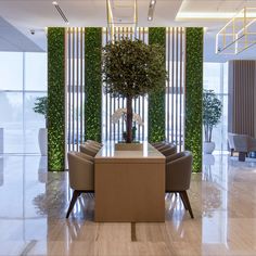 a dining room table surrounded by chairs and a tree in the middle of the room