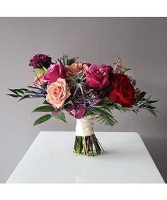 a bouquet of flowers sitting on top of a white table