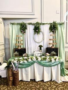 the table is set up with flowers and greenery on it for a wedding reception