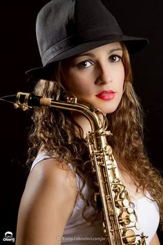 a woman wearing a hat and holding a saxophone