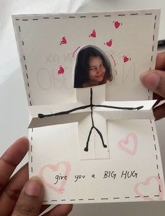 someone is holding up a small card with a photo on it