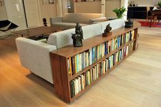 a living room filled with lots of furniture and bookshelves on top of it