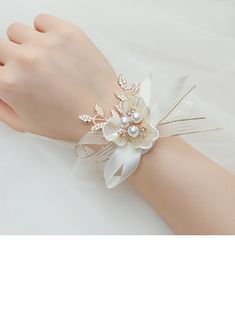 a woman's hand wearing a white flower bracelet