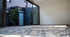 an open door on the outside of a house with stone flooring and brick walls