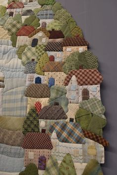 a quilted wall hanging with houses on it