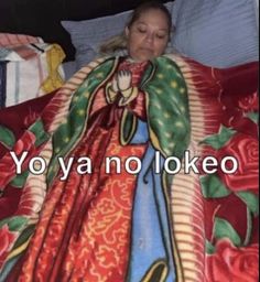 a woman laying in bed wrapped in a blanket with roses on it and the words yo ya no looked