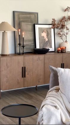 a living room filled with furniture and pictures on top of the wall next to a coffee table