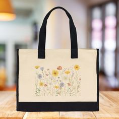 The Wildflower 100% Cotton Tote Bag. This Floral Tote Bag for Women features a captivating wildflower design that will add a splash of nature-inspired beauty to your daily routine. Measuring a generous 17” x 14” x 6”, this eco-friendly reusable bag is crafted from 100% cotton with reinforced stitching, ensuring both durability and elegance. It's roomy enough for beach days, picnics, errands, and everything in between, making it your new go-to bag for all your adventures. Wildflower Design, Craft Tote, Floral Tote Bag, Cotton Tote Bag, Floral Gifts, Reusable Bags, Sioux, Eco Conscious, Beach Days