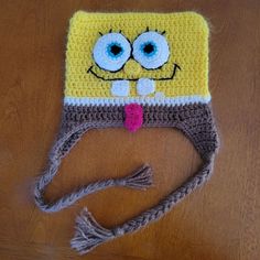 a crocheted spongebob hat on a wooden table