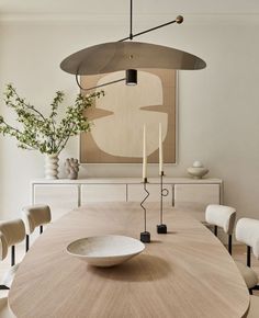 a dining room table with chairs and a bowl on it