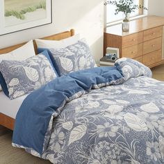 a bed with blue and white comforters in a bedroom