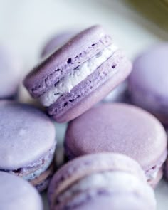 purple and white macaroons are stacked on top of each other