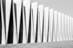 a black and white photo of the exterior of a building with tall columns in front of it