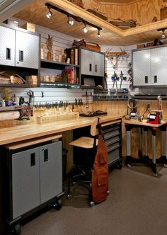 a workbench with lots of tools on the counter and cabinets above it in a garage