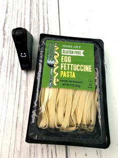 an egg fettuccine pasta in a package next to a remote control