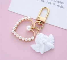 a keychain with a flower and pearl beads attached to it on a pink surface