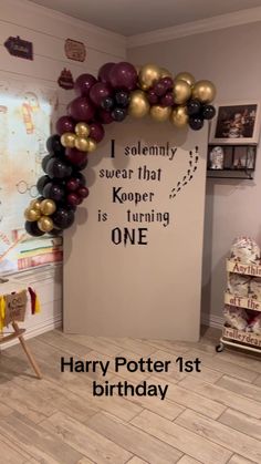 a room decorated with balloons and a sign that says harry potter 1st birthday