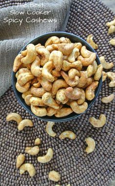 a bowl filled with cashews sitting on top of a table next to a towel