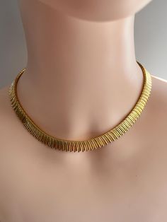 Beautifully classical Cleopatra revival style necklace in gold tone metal.  It has a smooth finish with a fluted design which makes the fronds form a feathery design to the edge of the necklace.  Has a metal tag attached with letter 'N'. Length is 41 cm plus additional chain of 3 cm (16" plus 3 cm).  Height of necklace is 1cm (0.30"). Sizes approximate. Very good vintage condition.  Vintage items may show some signs of wear, please see photos as they form part of the description. Cleopatra Jewelry, Cleopatra Style, Metal Tag, Metal Tags, Gold Tone Necklace, Choker Necklaces, Style Necklace, Gold Tone Metal, Halloween Shopping