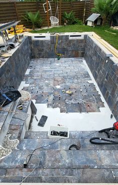 a pool being built in the middle of a yard with tools and equipment around it