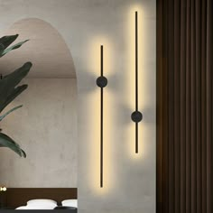 a room with a plant and two lights on the wall