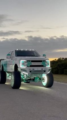 a white truck driving down a street next to trees