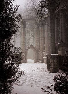 an old building with columns in the snow