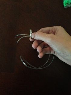 a person is holding scissors and string on a table