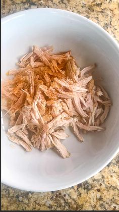 shredded meat in a white bowl on a counter