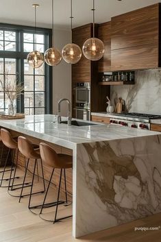 a kitchen with marble counter tops and bar stools in front of large glass windows